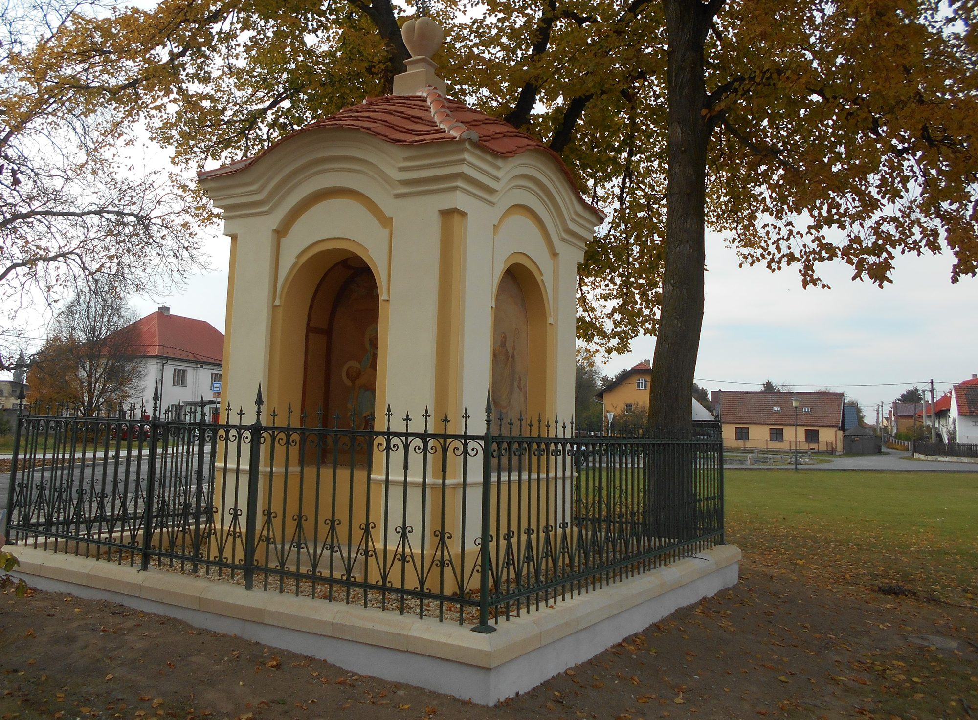 Opravená kaplička s kovaným oplocením